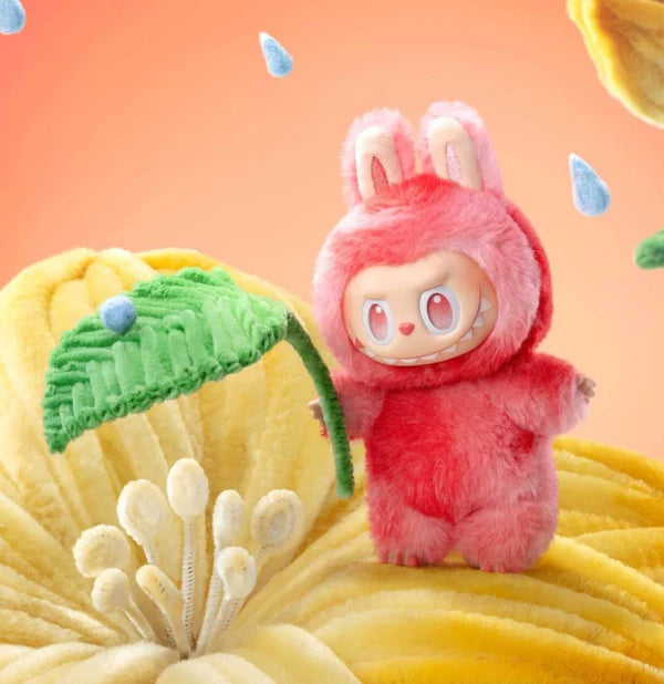 Plush toy with pink bunny ears and dress standing on a yellow textured surface with a green leaf.